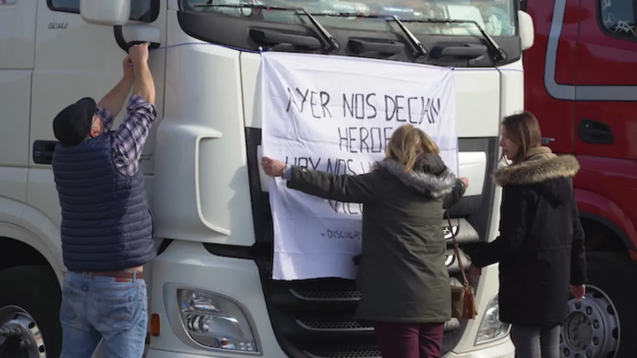 Varias personas pegan un cartel a un cami&oacute;n estacionado en la estaci&oacute;n de servicioAlberto Ruiz / Europa Press