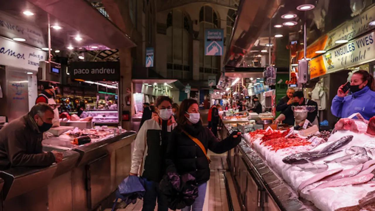 Dos personas pasan por un puesto de pescado en el Mercado Central de Valencia, a 24 de marzo de 2022, en Valencia, Comunidad Valenciana, (Espa&ntilde;a). La Asociaci&oacute;n de Supermercados de la Comunitat (ASUCOVA), la Asociaci&oacute;n Valenciana de Consumidores y Usuarios (AVACU) y Mercaval&egrave;ncia descartan que haya riesgo de desabastecimiento de productos por la huelga de transportistas, aunqu