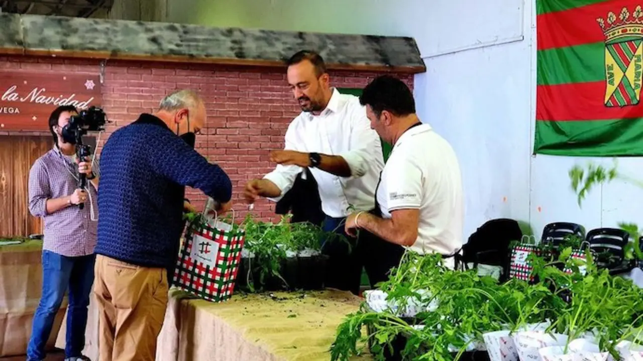 El alcalde Javier L&oacute;pez Estrada repartiendo tomates a los ciudadanos.