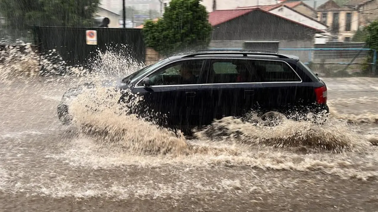 Un coche circula por una calle de Oviedo que se encuentra inundada tras las &uacute;ltimas lluvias registradas en la regi&oacute;n. Todoel Principado, salvo la franja litoral, se encuentra hoy en alerta amarilla ante el riesgo de fuertes tormentas y precipitaciones que pueden alcanzar los 15 litros en una hora a partir del mediod&iacute;a y que pueden presentarse tambi&eacute;n en forma de granizo. EFE/Paco Paredes