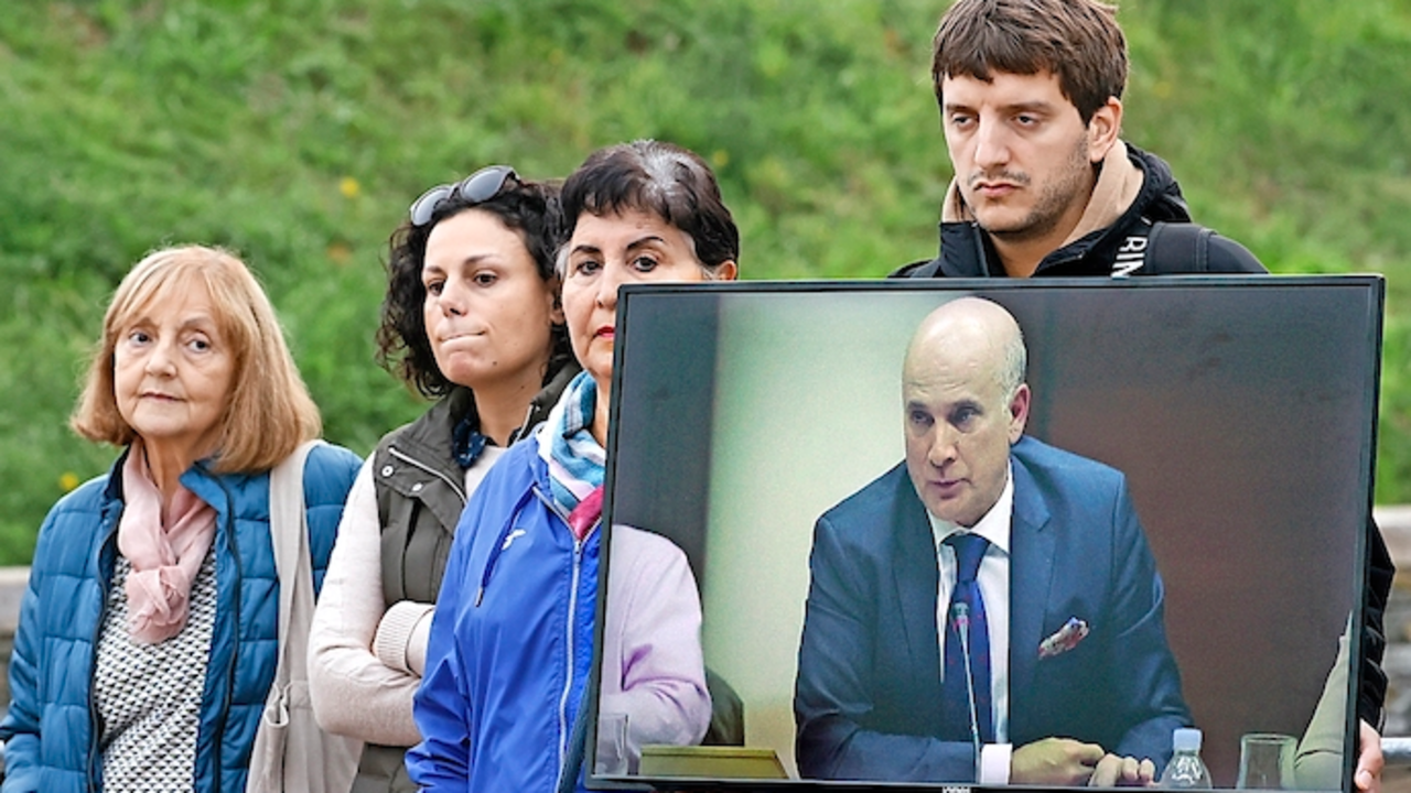 SANTIAGO DE COMPOSTELA, 13/10/2022.- Familiares de las v&iacute;ctimas muestran un video de Andr&eacute;s Cortabitarte, exjefe de Seguridad en la circulaci&oacute;n de Adif y segundo y &uacute;ltimo de los acusados por la muerte de 80 personas, este jueves, durante una nueva sesi&oacute;n del juicio por el accidente del Alvia, en la Ciudad de la Cultura de Santiago de Compostela. EFE/Lavandeira jr.
