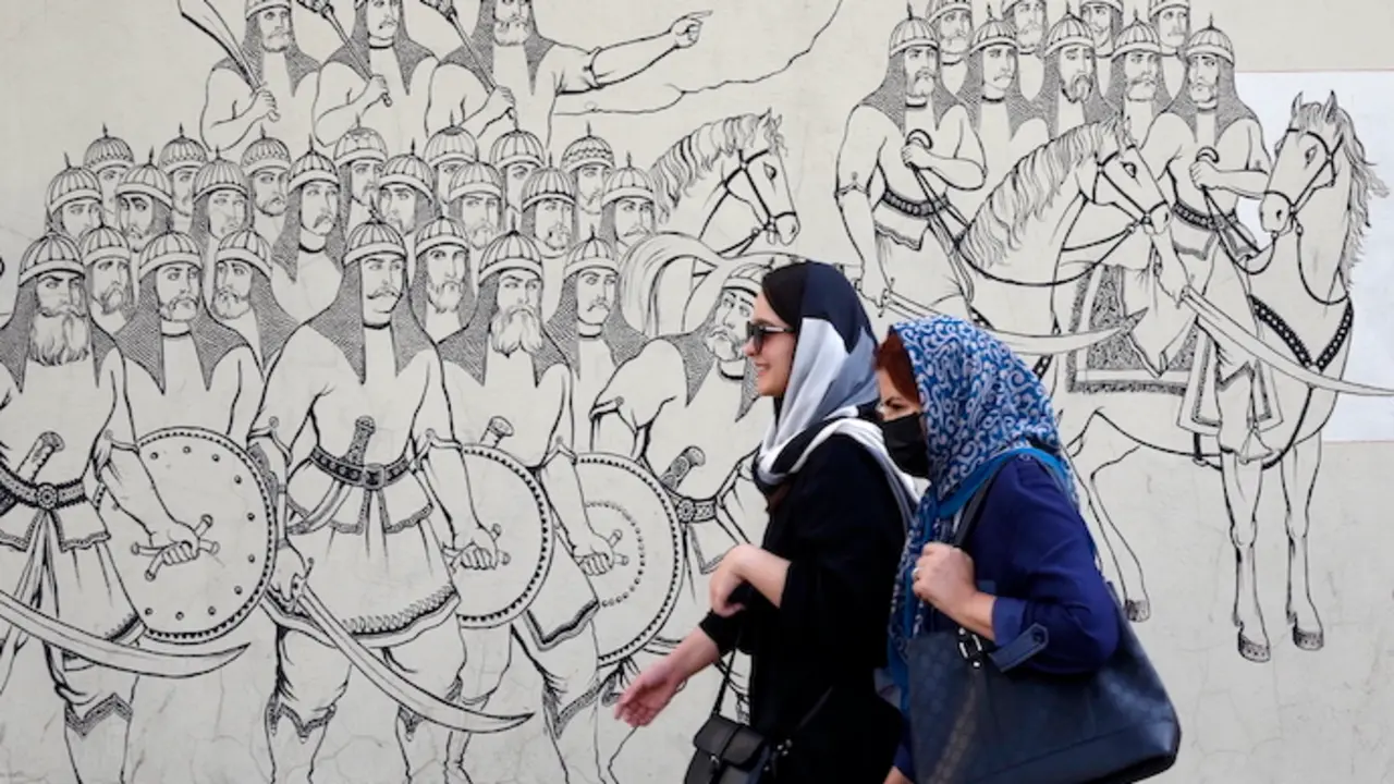Mujeres iran&iacute;es pasan junto a una pintura mural en una calle de Teher&aacute;n, Ir&aacute;n. / efe/ ABEDIN TAHERKENAREH