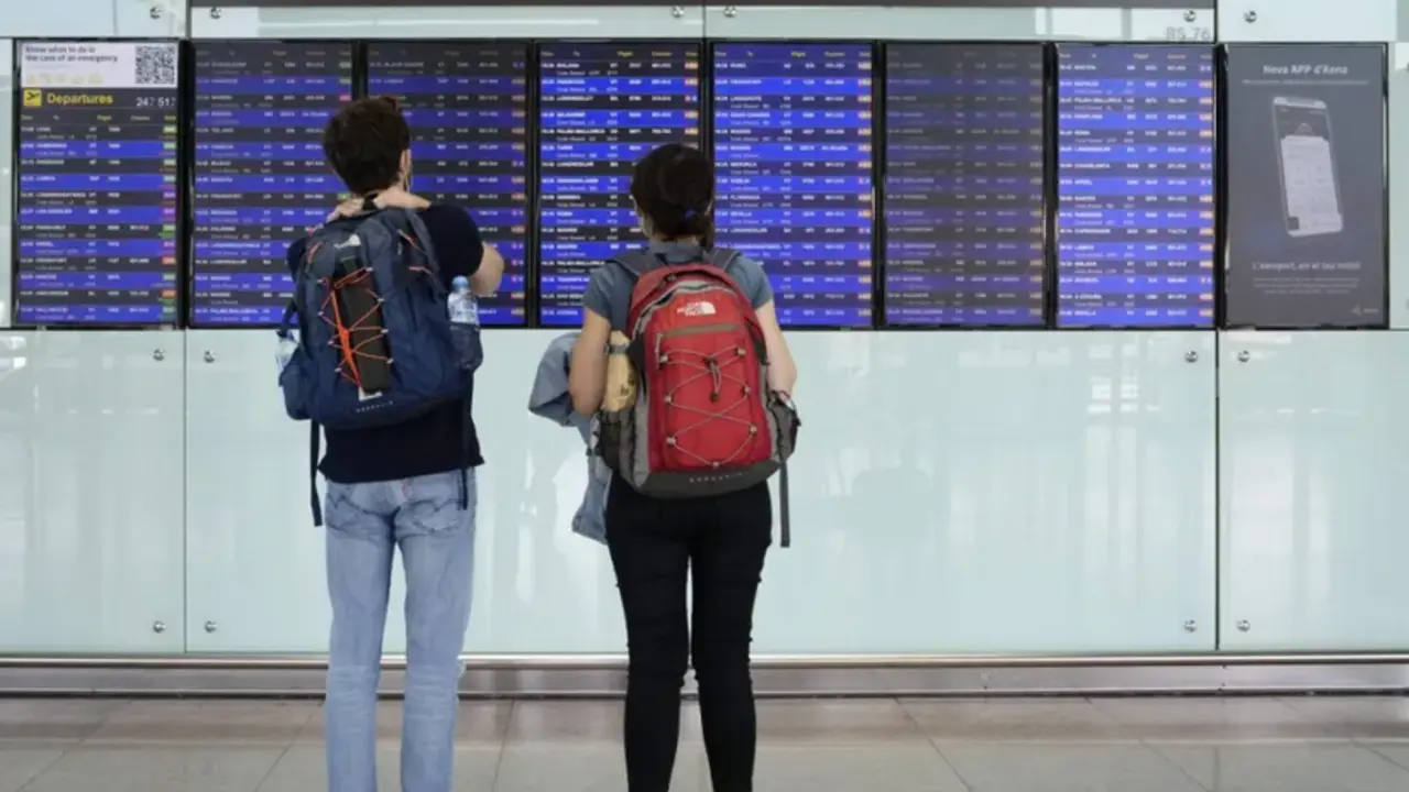 Dos viajeros consultaban los paneles con los vuelos programados en el aeropuerto de El Prat, en Barcelona, en la primera de las jornadas de huelga en la aerol&iacute;nea Vueling, el pasado 14 de noviembre. EFE/Enric Fontcuberta
