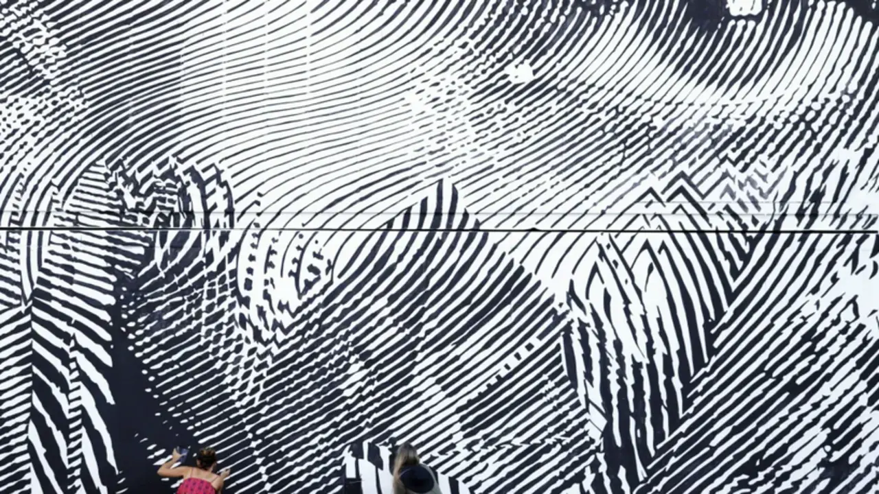 Dos artistas retocan un mural del artista 2Alas, que hace parte de la segunda edici&oacute;n del festival "Color Caribe", en Dorado (Puerto Rico). EFE/Thais Llorca
