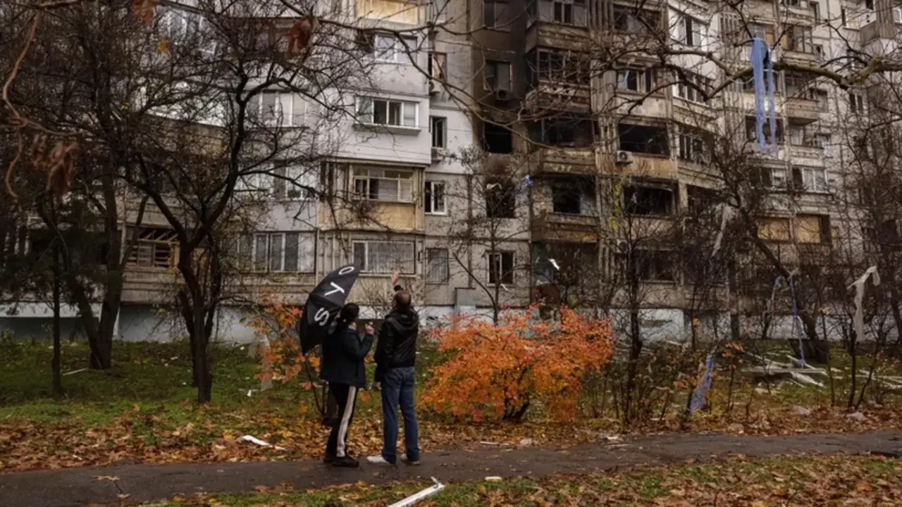 Ucranianos delante de un edificio da&ntilde;ado por bombas rusas en Jers&oacute;n. EFE/EPA/ROMAN PILIPEY