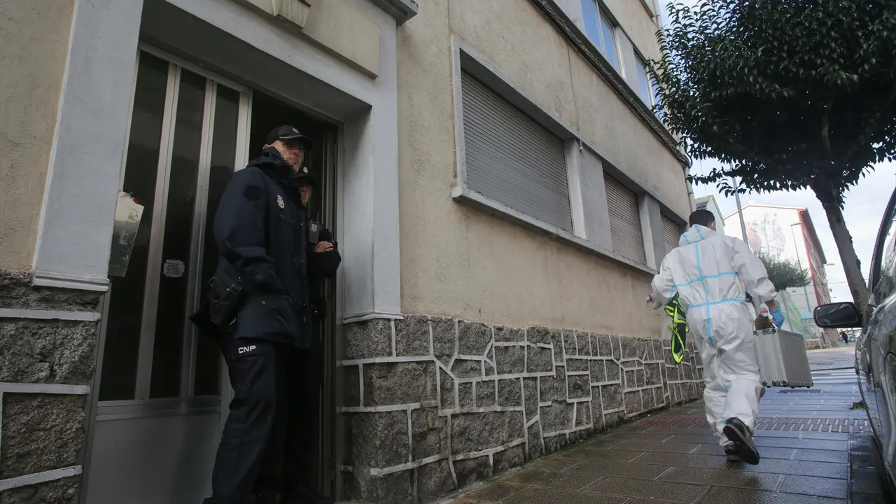 Un agente de Polic&iacute;a Nacional en la puerta de la vivienda donde han hallado muerta a una mujer de 42 a&ntilde;os. E.P. / Carlos Castro
