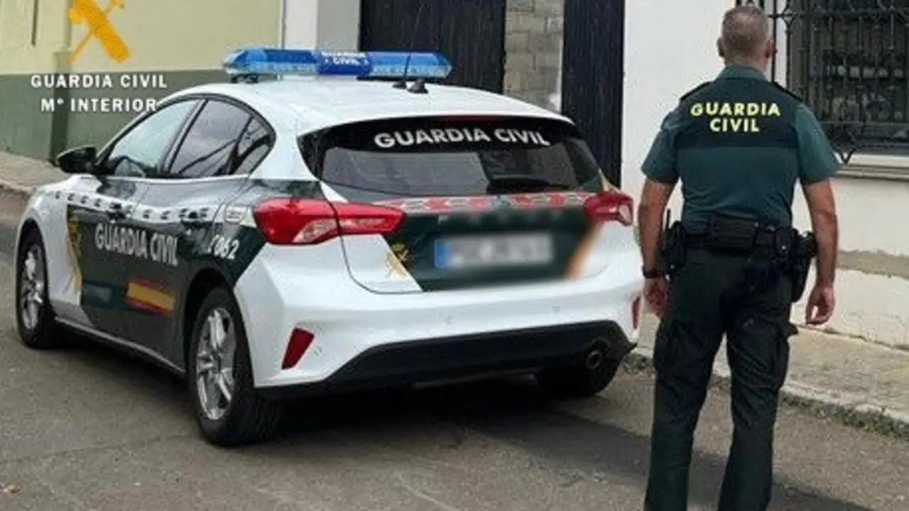 Vista de un agente y un coche de la Guardia Civil. E.P.