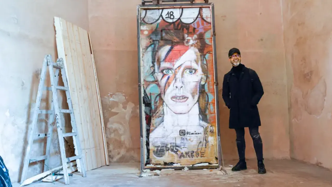 GRAFCVA245. VALENCIA, 12/12/2022.-El artista Jesus Arr&uacute;e posa con el el grafiti de David Bowie que dibuj&oacute; en un muro de la ciudad de Valencia y que ha sido trasladado desde la ubicaci&oacute;n callejera en el que fu&eacute; creado, al museo del Carme, que va a contar desde ahora con esta obra de arte urbano. EFE/ Manuel Bruque