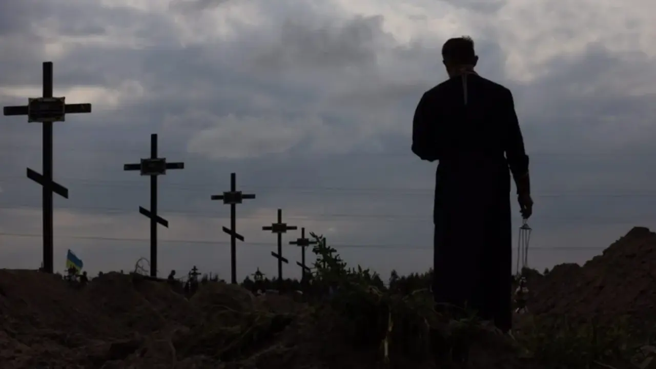 Un sacerdote ortodoxo bendec&iacute;a los restos de personas no identificadas que fueron asesinadas en el distrito de Bucha, al noroeste de Kiev, el pasado mes de agosto. EFE/EPA/Roman Pilipey