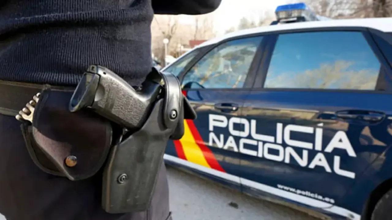 Un agente junto a un coche policial.C.A.D.