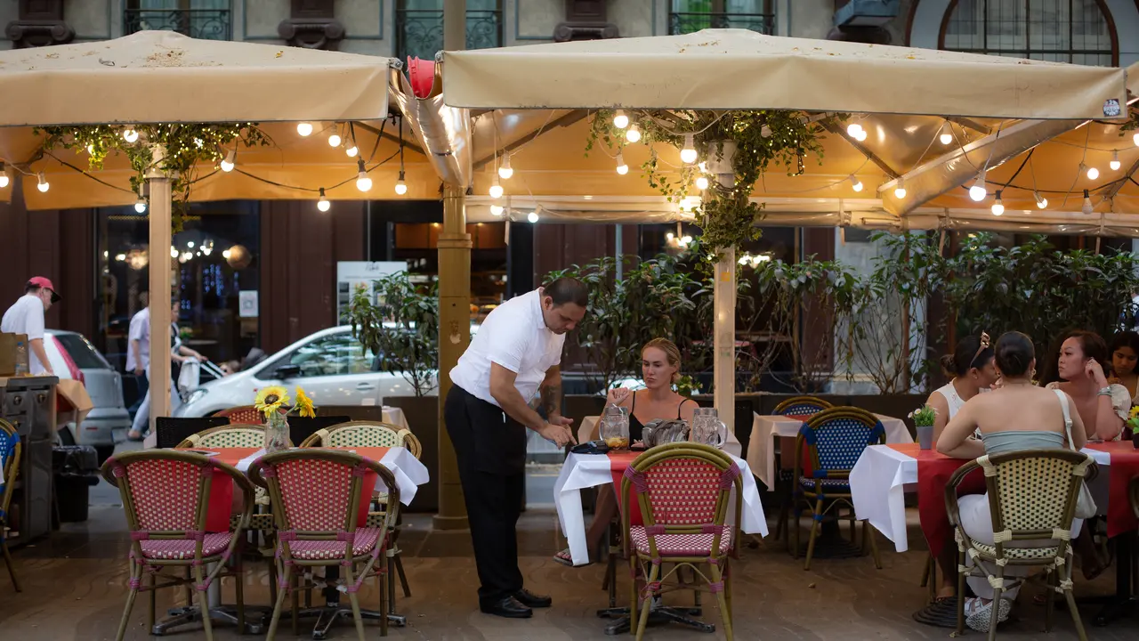 Un camarero atiende a una mesa en las Ramblas. / David Zorrakino