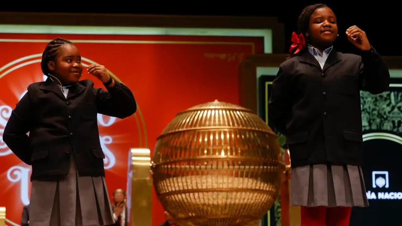 de San Ildefonso Yesica Paola Valencia G&oacute;mez (d) y su compa&ntilde;era Ainhoa Rosero G&oacute;mez (i) cantan un quinto premio durante el sorteo de El Gordo de Navidad en el Teatro Real en Madrid, este jueves. EFE/ Javier Liz&oacute;n