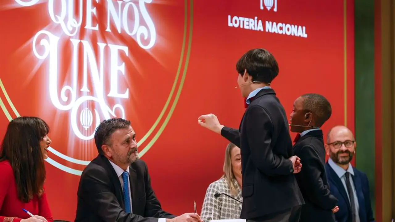 Los estudiantes de San Ildefonso Alonso D&aacute;valos Dur&aacute;n (3d) y su compa&ntilde;ero &Aacute;ngel Abaga Elebiyo (2d) cantan el premio Gordo durante el sorteo de Navidad en el Teatro Real en Madrid, este jueves. EFE/ Javier Liz&oacute;n