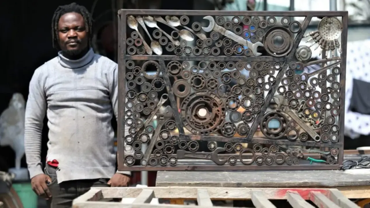 El artista Abinoro Akporode Collins junto a una de sus obras. EFE/Akintunde Akinleye