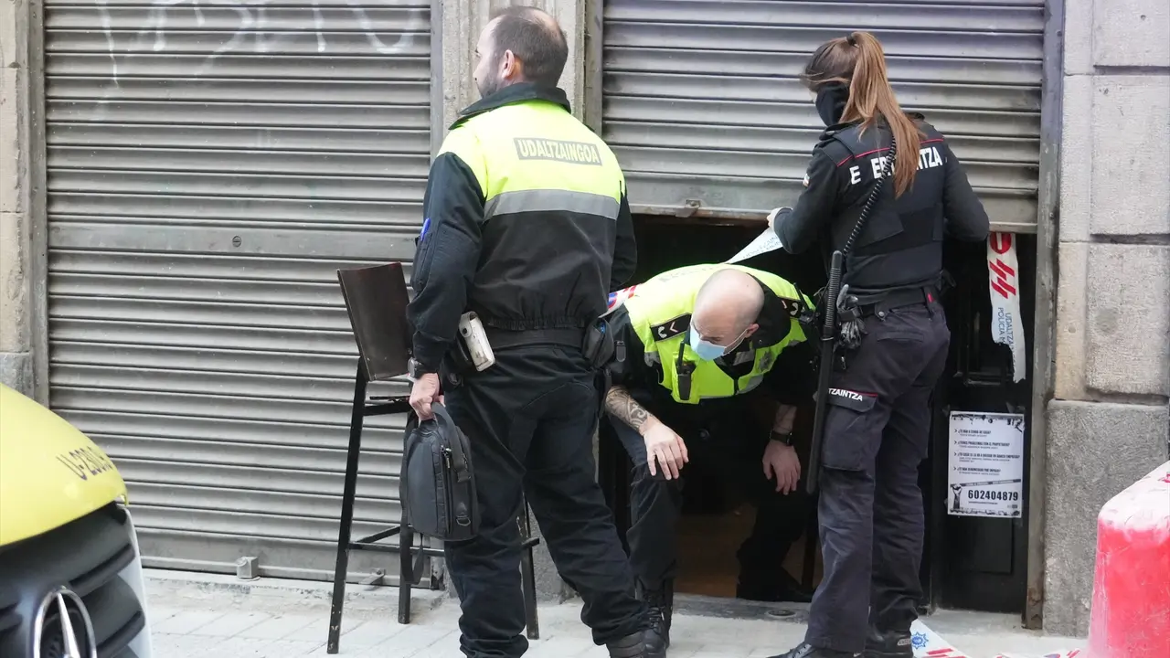 Dos agentes de la Polic&iacute;a Municipal y una de la Ertzaintza salen de la taberna Hiargi, donde ha tenido lugar el suceso. H. Bilbao