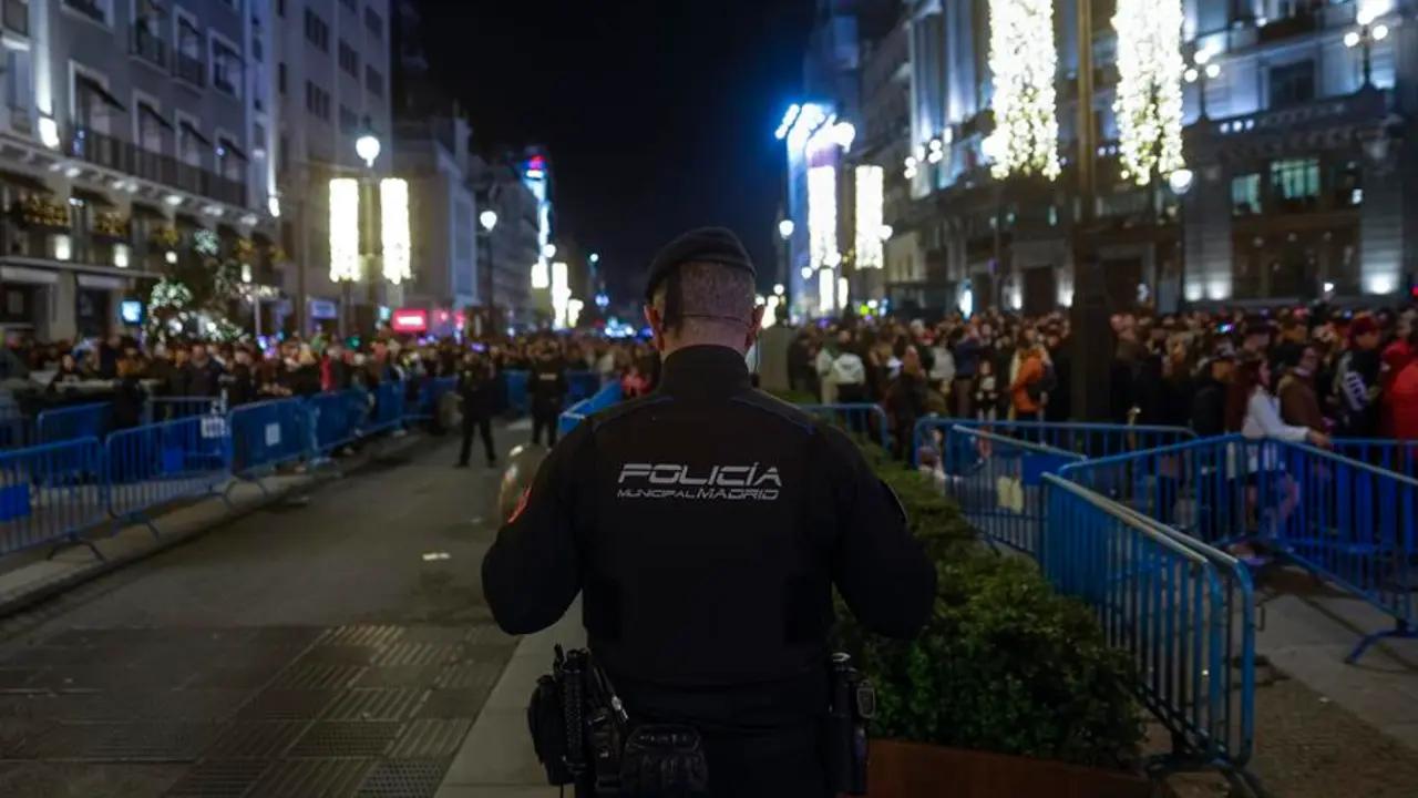 Un polic&iacute;a presta guardia en una calle que re&uacute;ne a decenas de ciudadanos. EFE / Daniel Gonz&aacute;lez