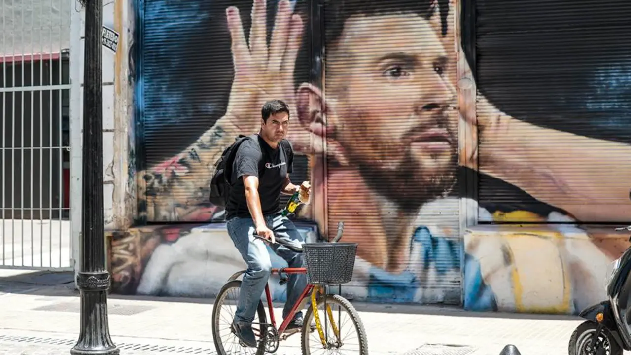 Un hombre en bicicleta pasa frente a un mural dedicado a Lionel Messi, en Buenos Aires (Argentina). EFE / Juan Ignacio Roncoroni