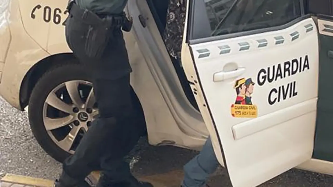 Un guardia civil introduce en el coche a un detenido. E.P.