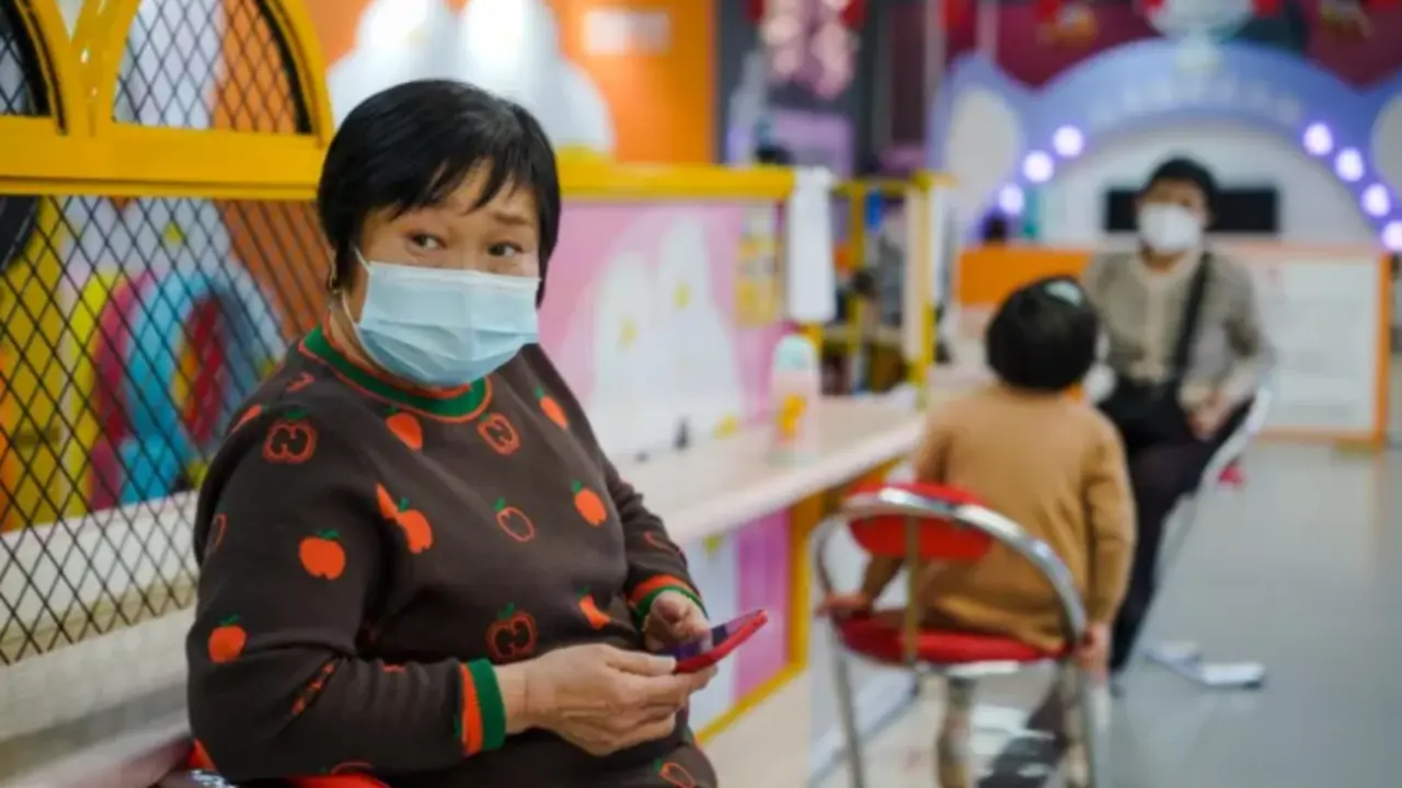 Una mujer protegida con una mascarilla utiliza su m&oacute;vil en un centro comercial de Pek&iacute;n el pasado 11 de enero. EFE / Wu Hao