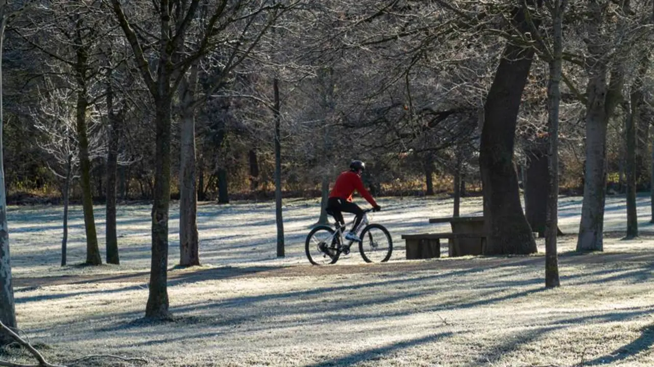 Un hombre pasea en bicicleta por el jard&iacute;n bot&aacute;nico de Olarizu de Vitoria cubierto de escarcha este s&aacute;bado. EFE / David Aguilar
