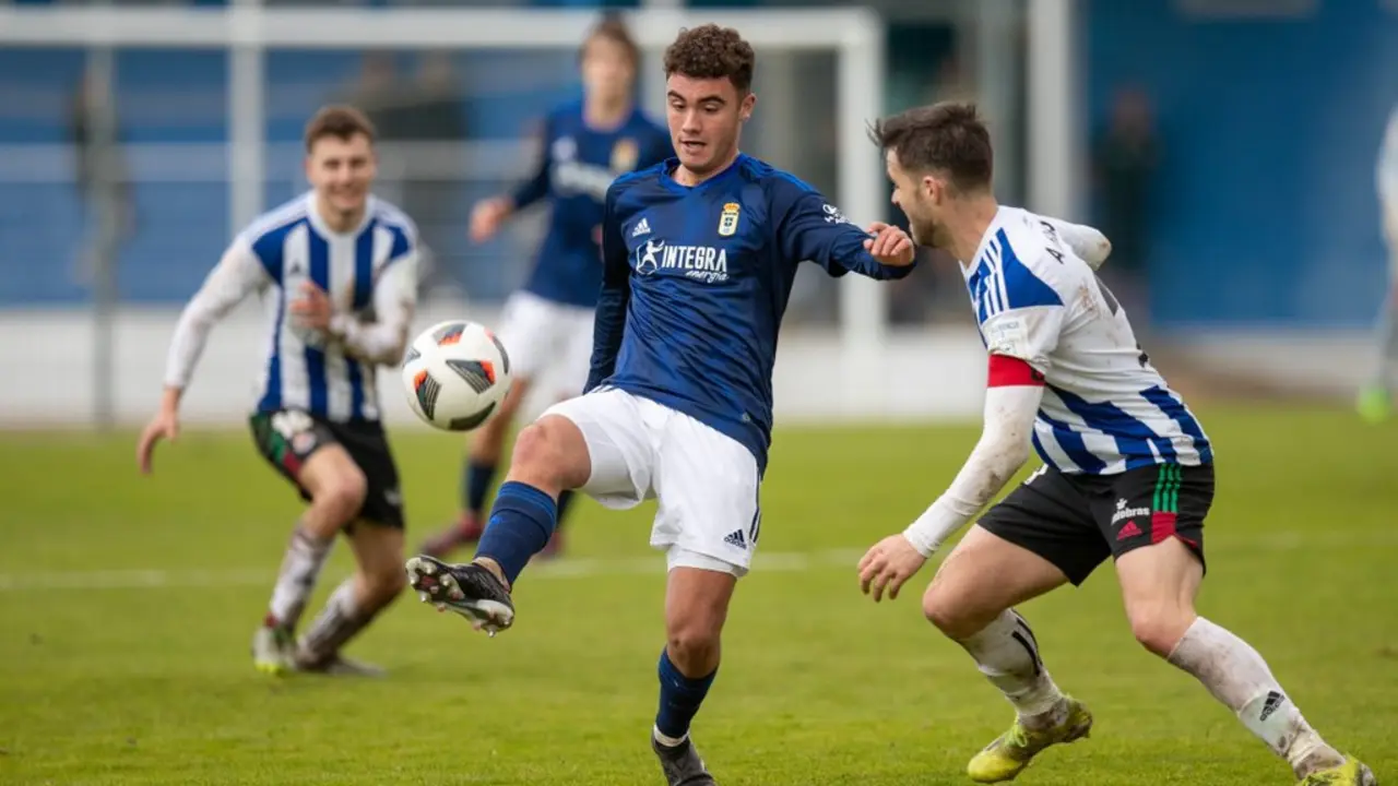 Un jugador del Oviedo controla el bal&oacute;n ante la presi&oacute;n gimn&aacute;stica.