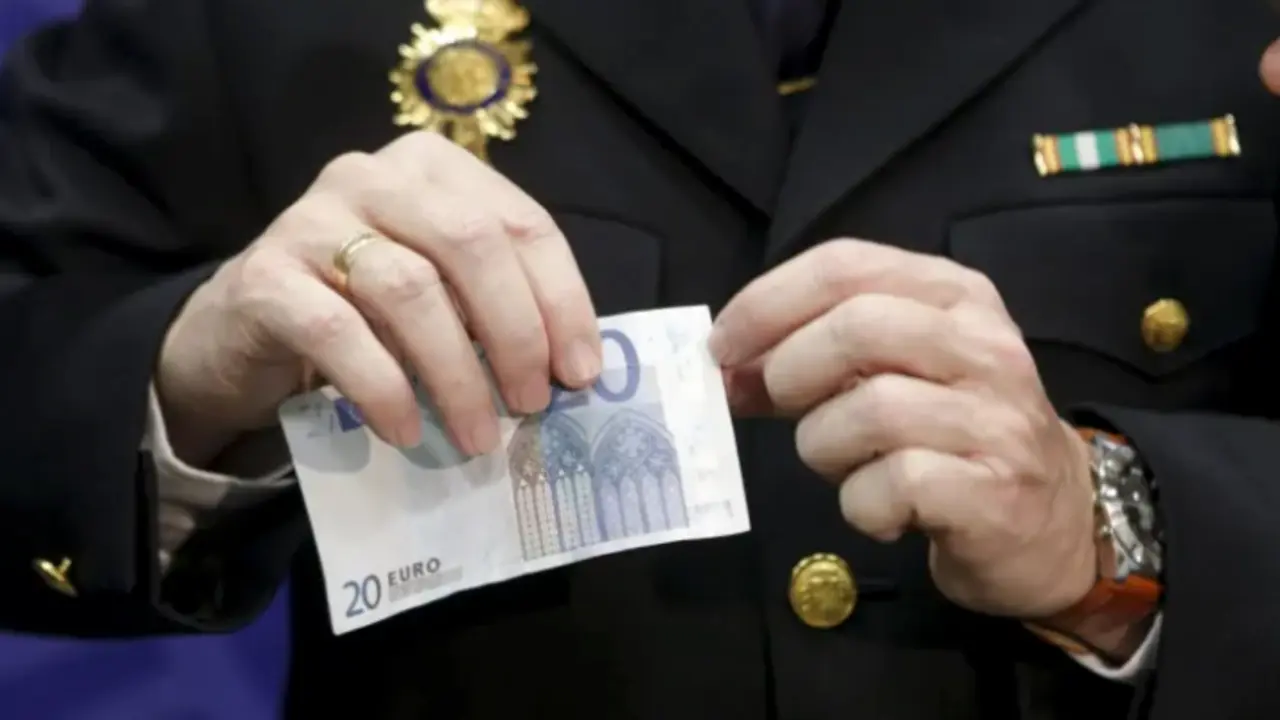 Un agente de Polic&iacute;a con un billete falso de 20 euros. EFE / &Aacute;ngel D&iacute;az
