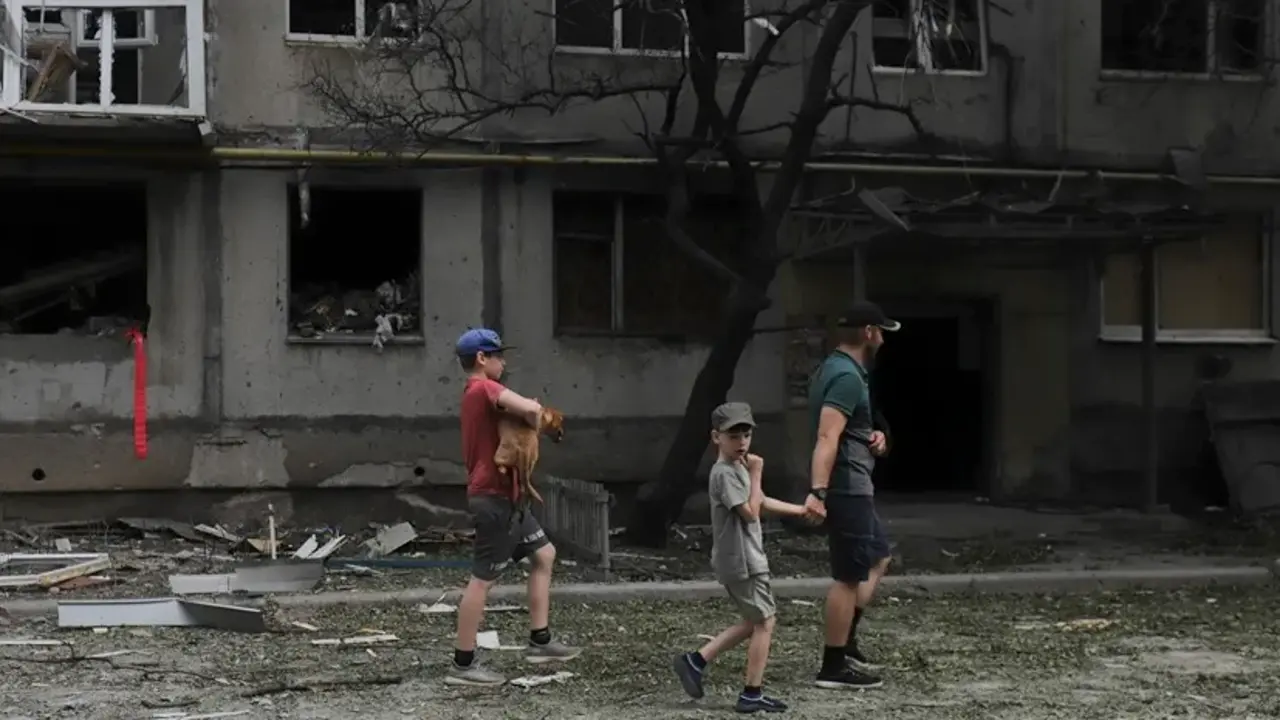 Varias personas en una calle de Bajmut, en la regi&oacute;n de Donetsk, en la que se aprecian los efectos de los bombardeos rusos. EFE