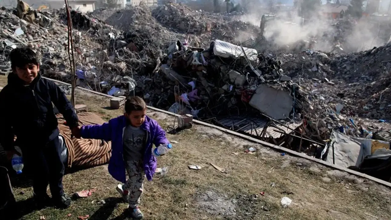 Unos ni&ntilde;os juegan junto a un solar de edificios derrumbados tras el terremoto en Kahramanmaras, Turqu&iacute;a. EFE / Tolga Bozoglu