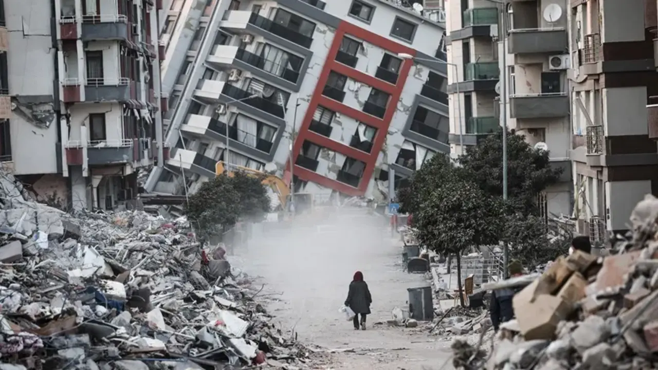 Una mujer pasa junto a edificios en ruinas, tras los terremotos de Turqu&iacute;a. EFE / Sedat Suna