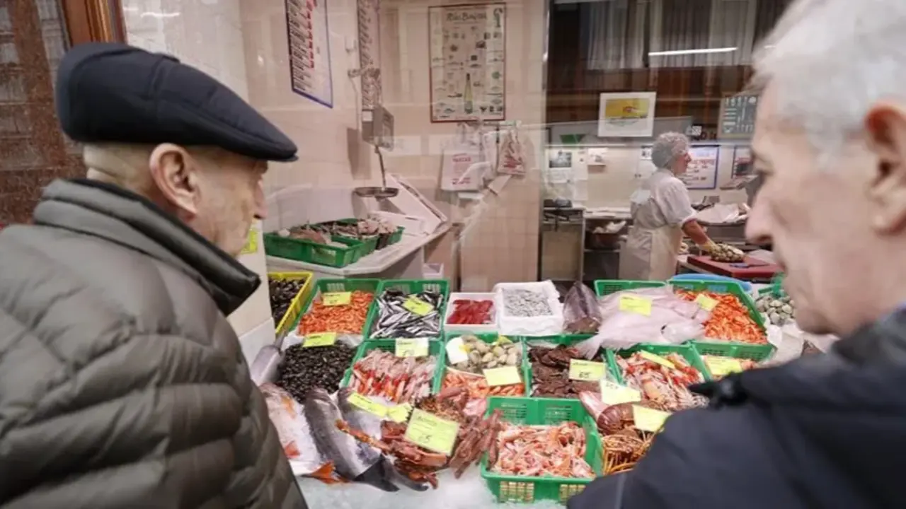 Dos personas observan el g&eacute;nero y precios de una pescader&iacute;a en Bilbao. EFE/Luis Tejido