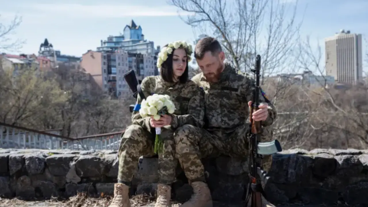 Dos miembros de las Fuerzas de Defensa Territorial de Kiev celebran su boda. EFE/Mikhail Palinchak