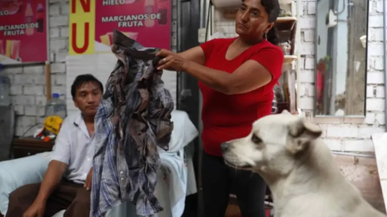 Una mujer muestra la camisa ensangrentada de Juan Carlos Vergaray, el 20 de febrero de 2023, en Lima (Per&uacute;). EFE/ Paolo Aguilar