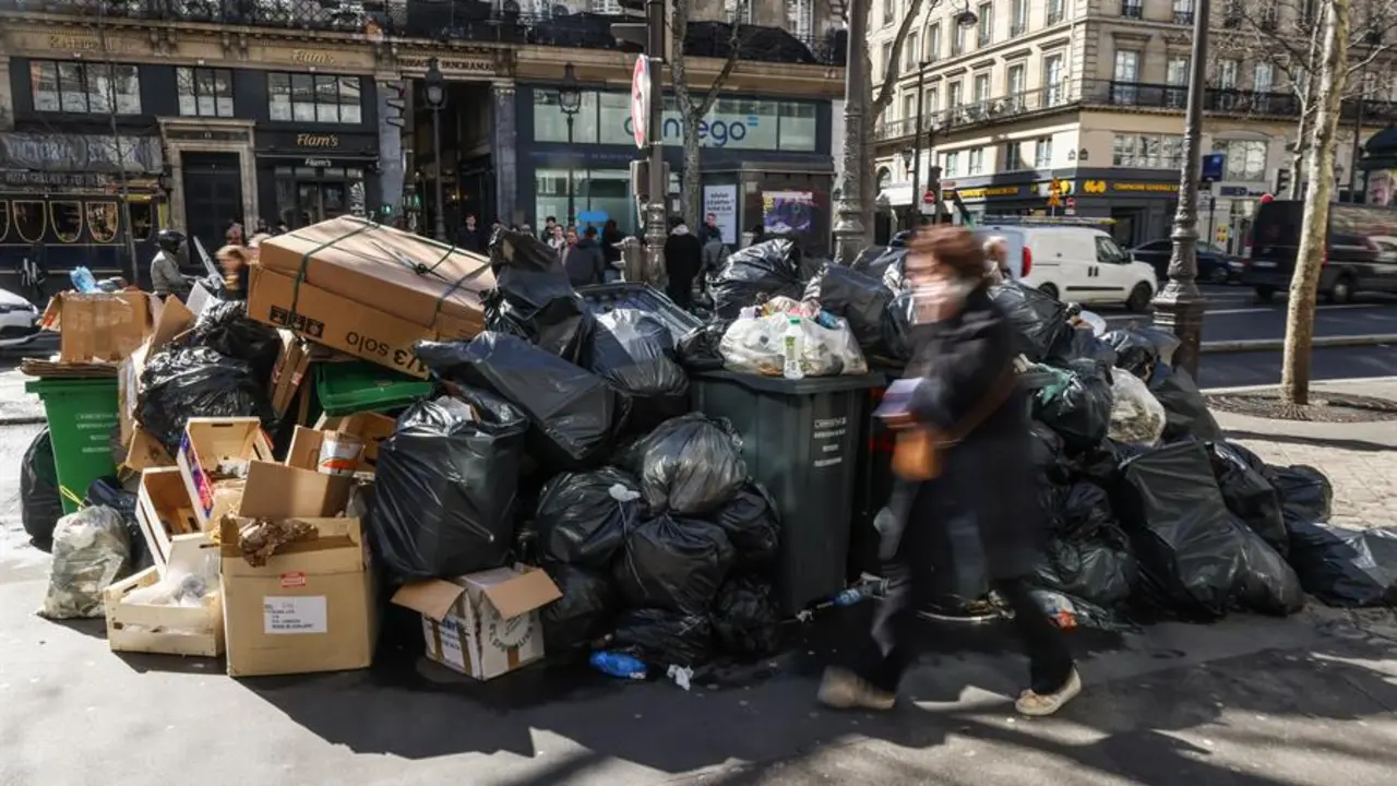 Una mujer camina frente a varias bolsas de basura en Par&iacute;s. EFE / Mohammed Badra
