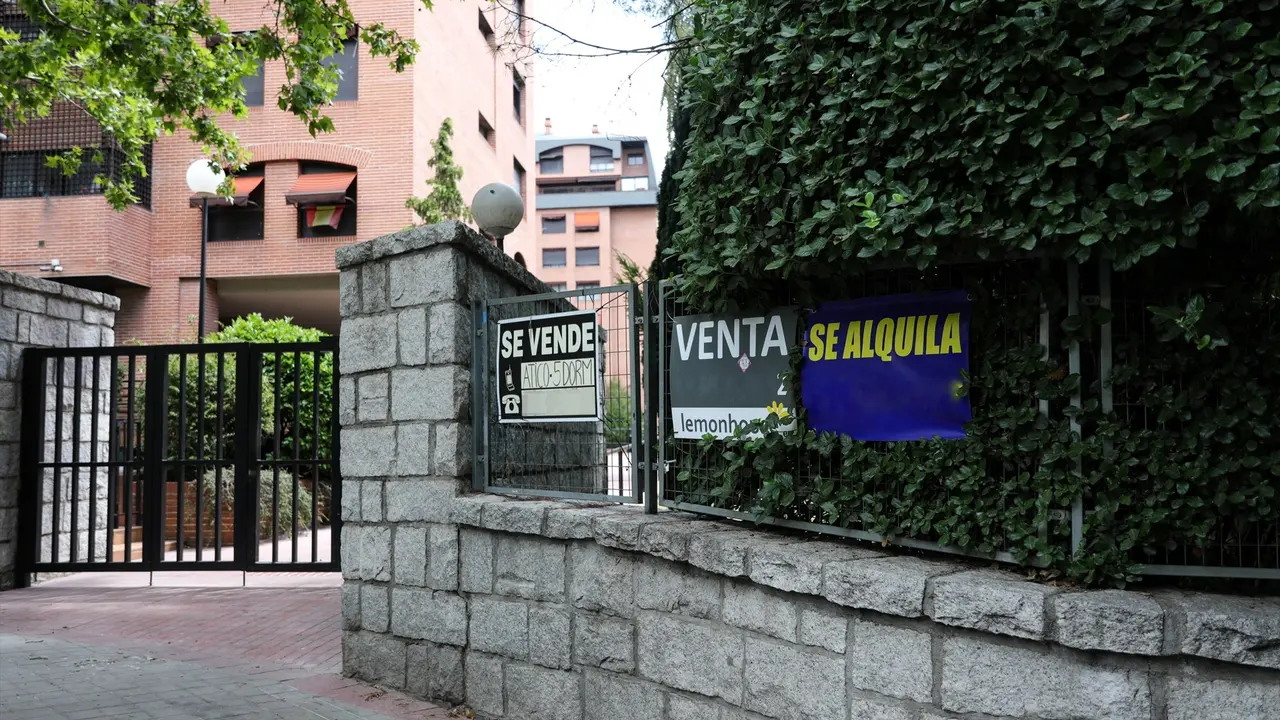 En la valla de una urbanizaci&oacute;n, se ven colgados dos carteles de 'Se vende piso' y uno de 'Se alquila'. EP / Jes&uacute;s Hell&iacute;n