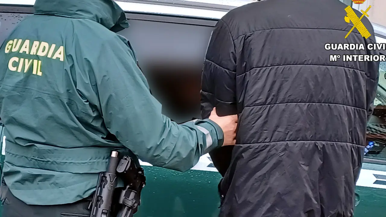 Un Guardia Civil custodia al detenido por el alunizaje.