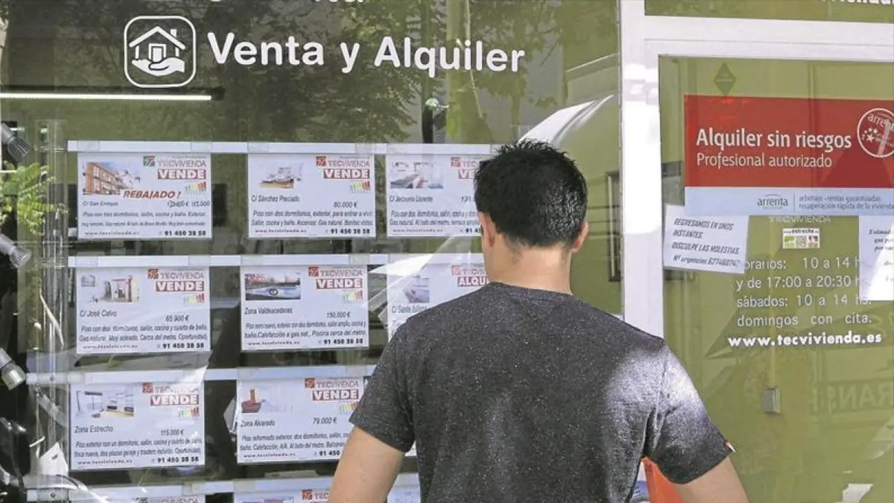 Un hombre mira el escaparate de una inmobiliaria. / Alerta