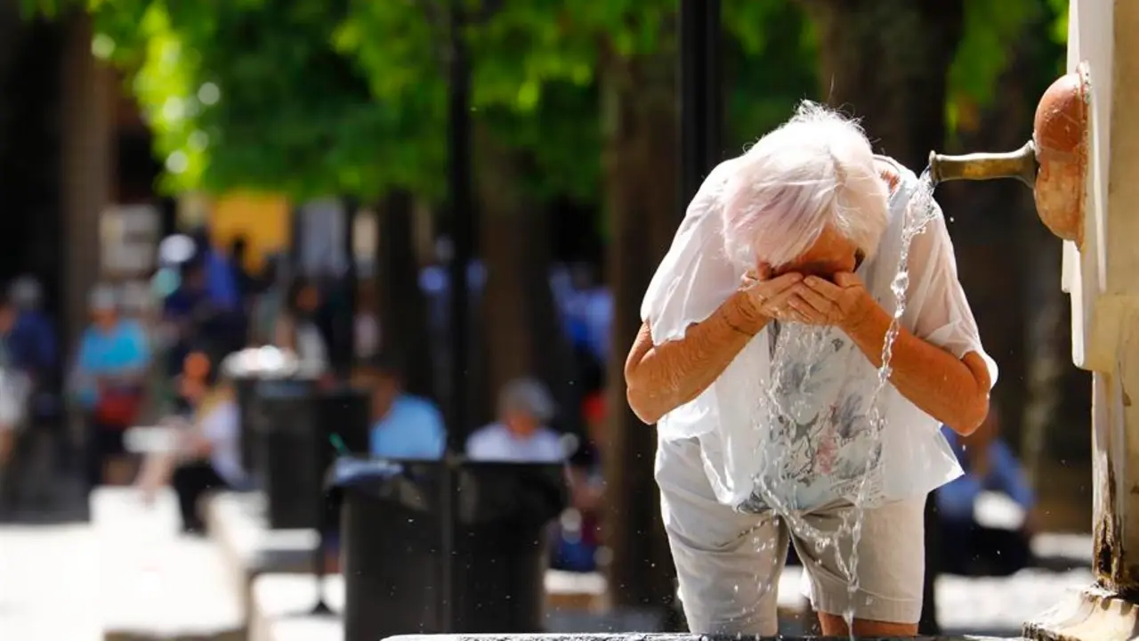 Una mujer se refresca en una fuente debido al calor sofocante. / A.E.