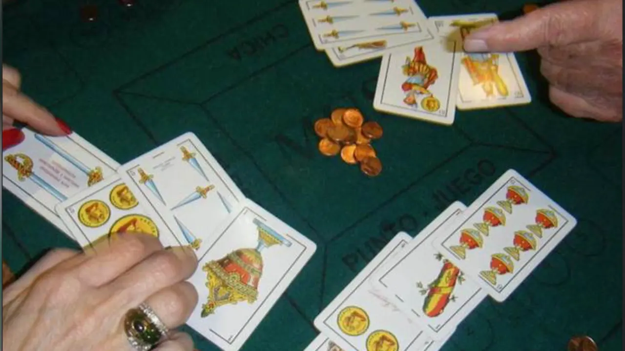 Varias personas jugando al mus.