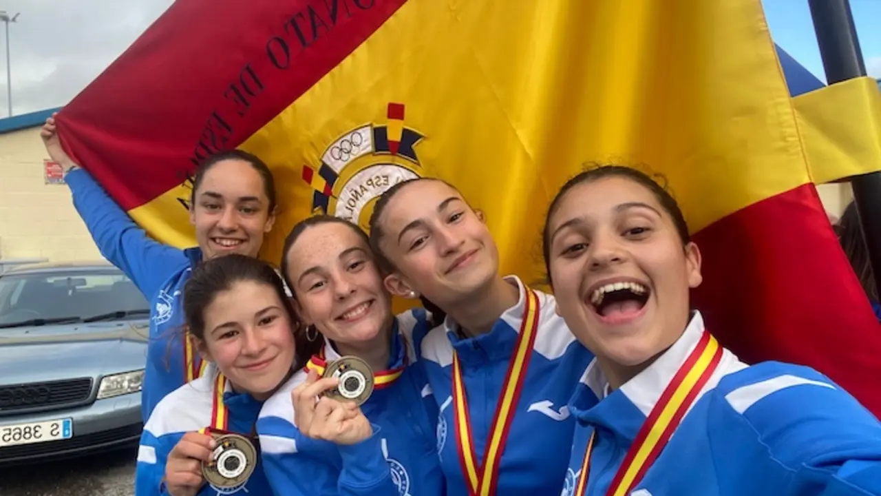 De derecha a izquierda (de m&aacute;s cerca a m&aacute;s lejos): Raquel Salazar, Sandra Santander, Manuela Narciso, Deva Campuzano y Jimena Fern&aacute;ndez, con la medalla de oro y la bandera de campeonas de Espa&ntilde;a.