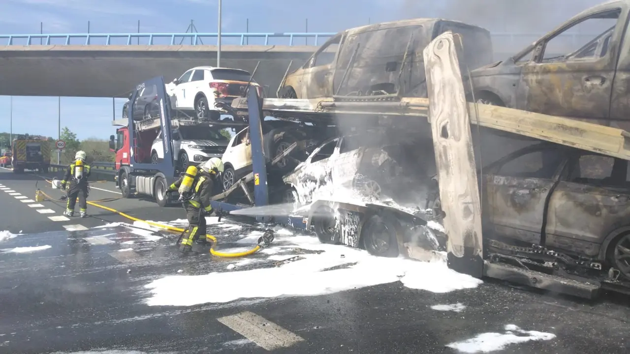 Bomberos apagando el incendio en el cami&oacute;n portacoches. / GC