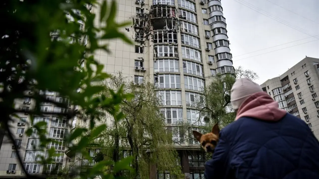 Una mujer mira un edificio da&ntilde;ado por la explosi&oacute;n de un dron ruso en Kiev. EFE / OLEG PETRASYUK
