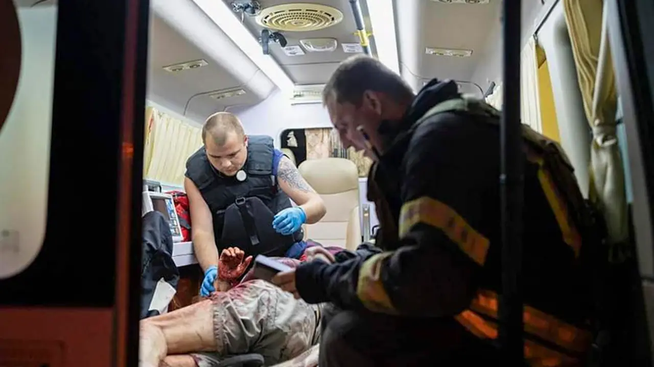 Trabajadores del Servicio Estatal de Emergencia (SES) de Ucrania atienden a una persona herida dentro de una ambulancia cerca de un edificio de apartamentos da&ntilde;ado despu&eacute;s de un ataque con drones en Kiev. EFE / STATE EMERGENCY SERVICE OF UKRAINE