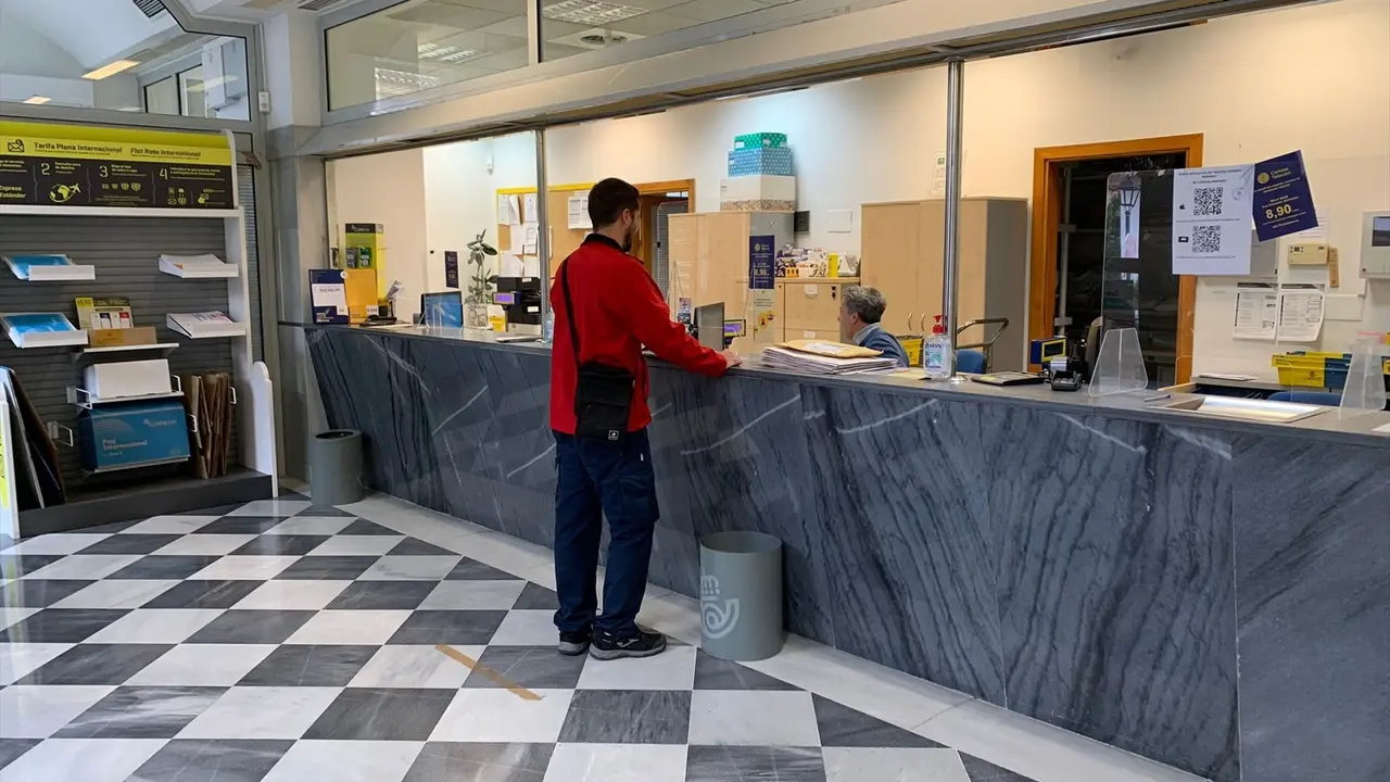 Una persona en una oficina de Correos. EP