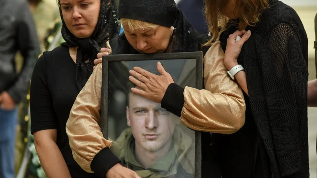 La madre de un soldado ucraniano abraza el retrato de su hijo durante su ceremonia f&uacute;nebre. EFE/ Oleg Petrasyuk