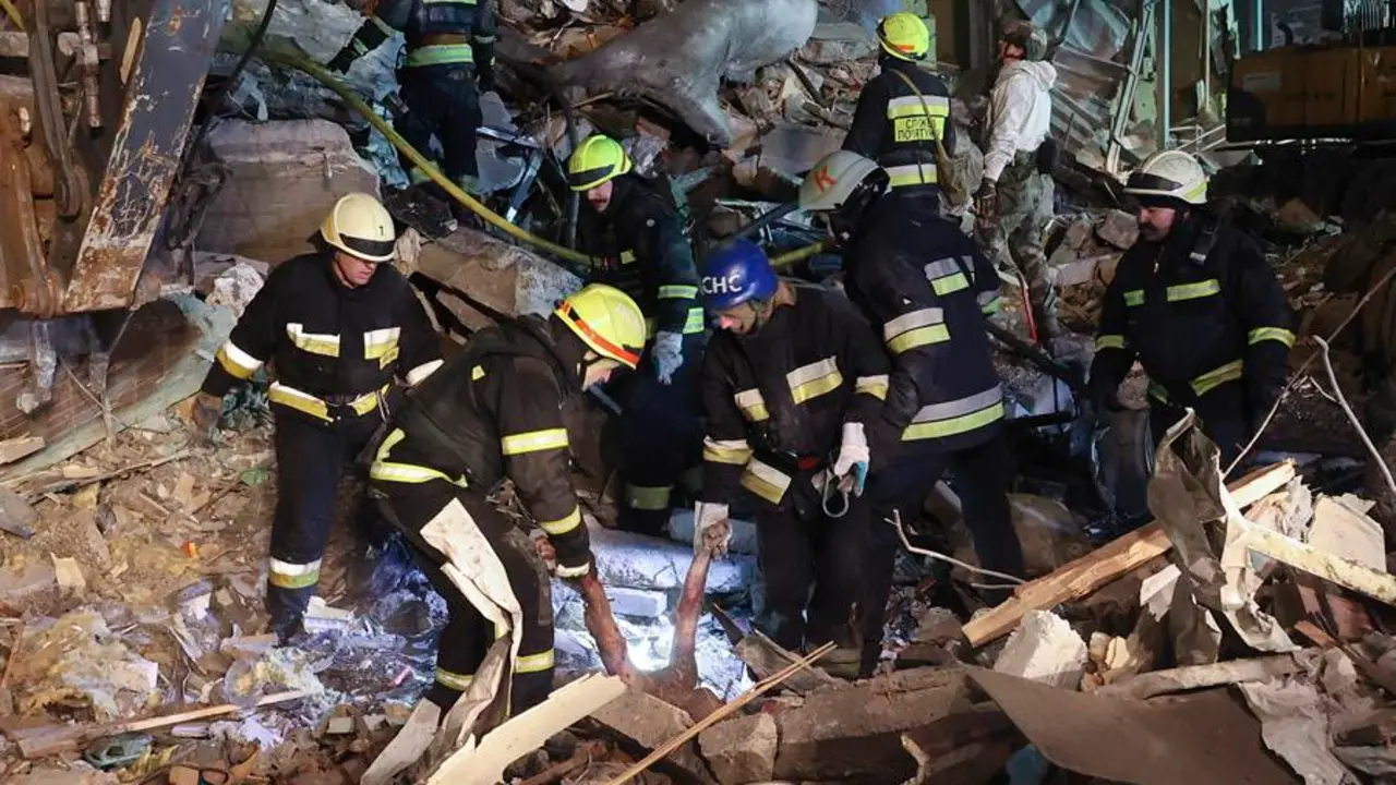 Un equipo de bomberos ucranianos buscando supervivientes entre las ruinas de un edificio alcanzado por un bombardeo ruso en la ciudad de Dnipro. EFE / SERGEY KOZLOV