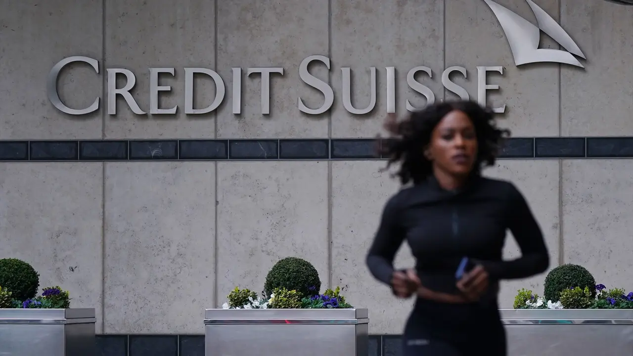 Una mujer caminando frente a las oficinas de Credit Suisse. EP / Yui Mok