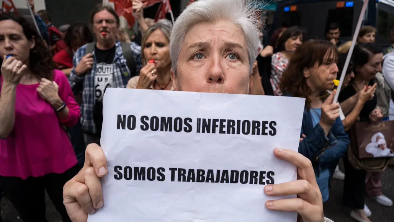 Una mujer sujeta una pancarta durante una protesta de los funcionarios de justicia frente a la sede nacional del PSOE de la calle G&eacute;nova. / Diego Radam&eacute;s