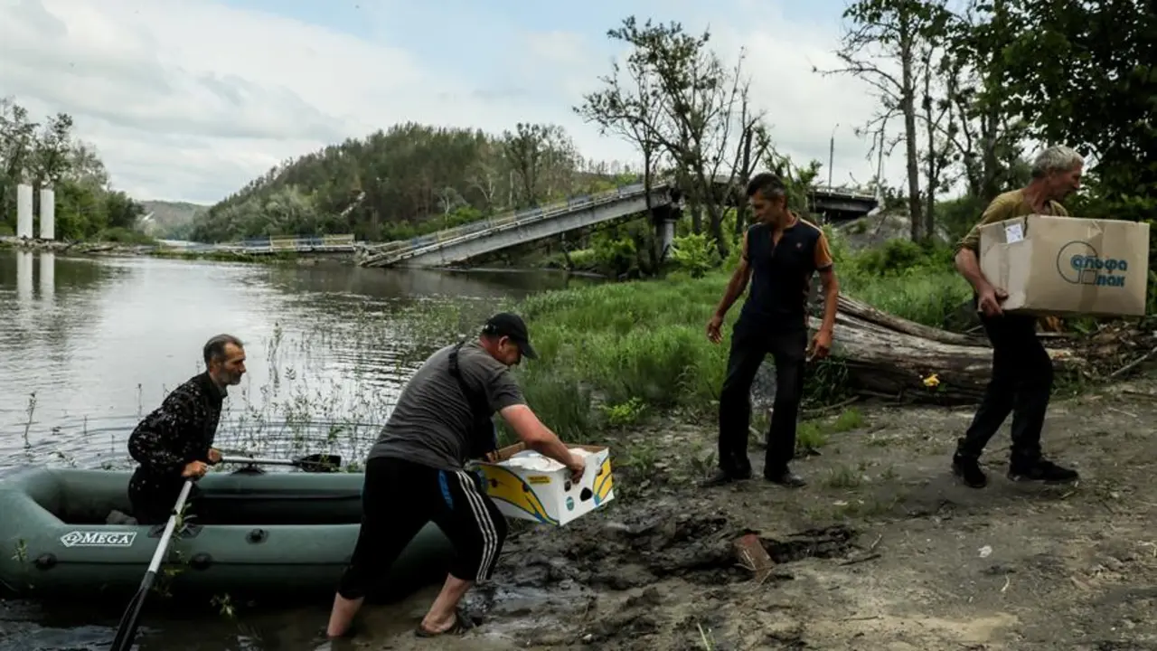 Unos hombres junto a una balsa en la zona inundada. EFE