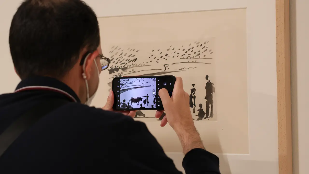 Un hombre fotograf&iacute;a con su tel&eacute;fono m&oacute;vil un dibujo de Picasso de la exposici&oacute;n. / Marta Fern&aacute;ndez
