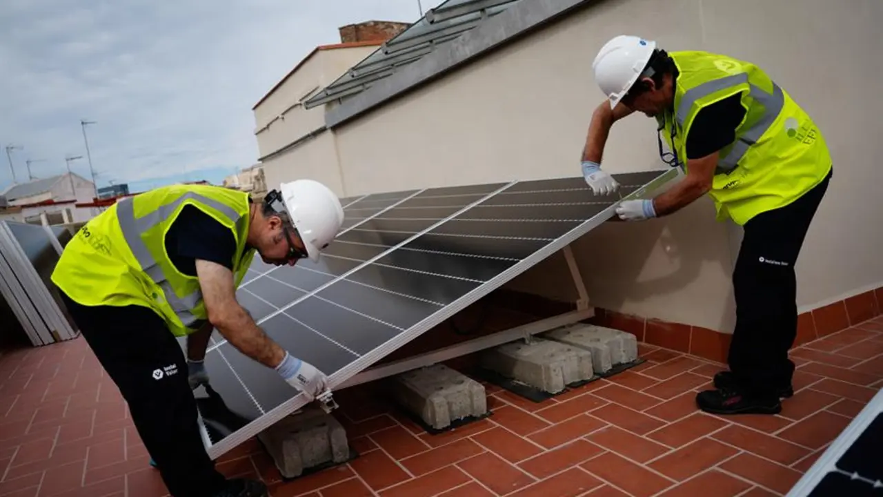 Operarios instalando placas solares en un edificio residencial de Barcelona. EFE / Enric Fontcuberta